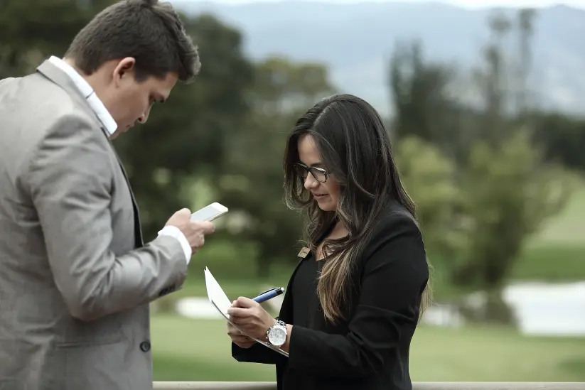 Two team members review notes before a ceremony