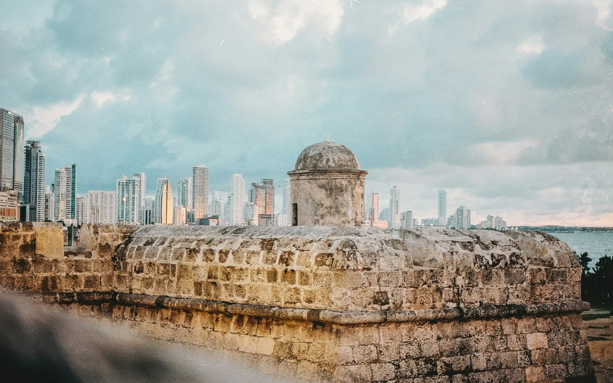 The old city walls with the bay and modern skyline behind