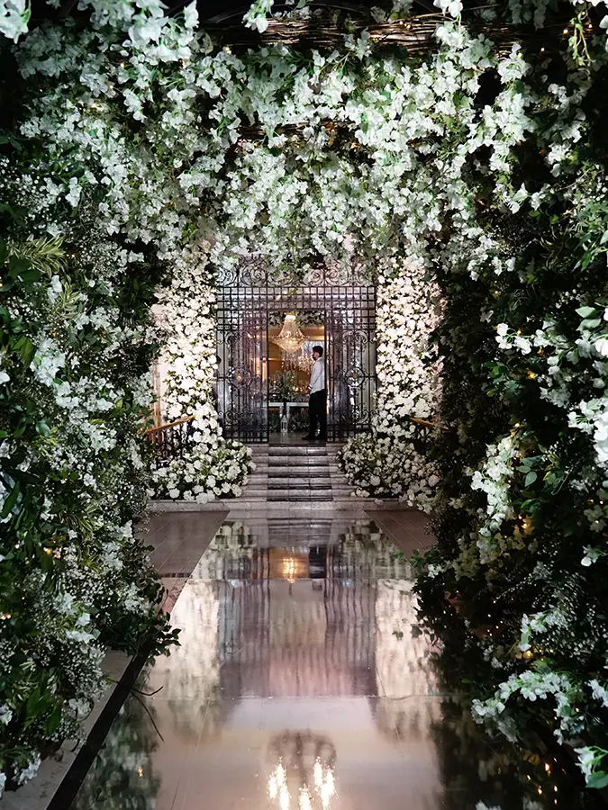 Ceremony aisle covered in greenery and white flowers